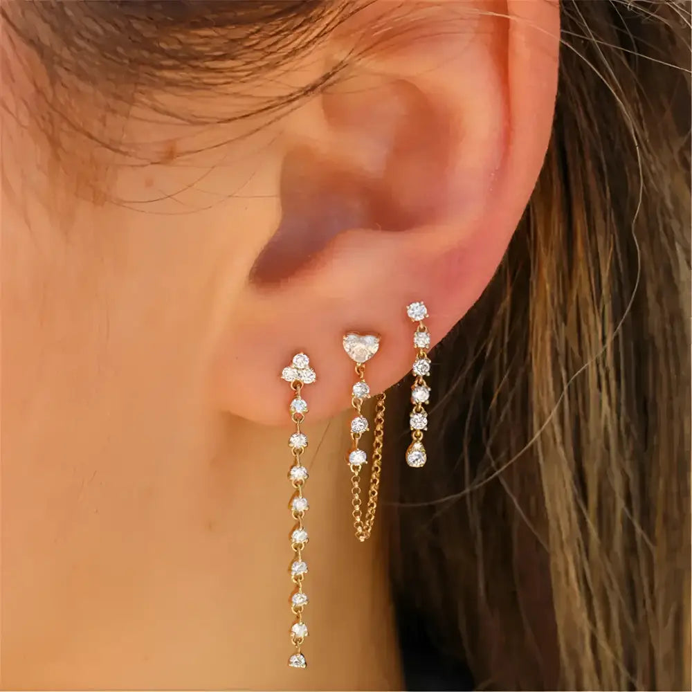 Ear with three dangling earrings.