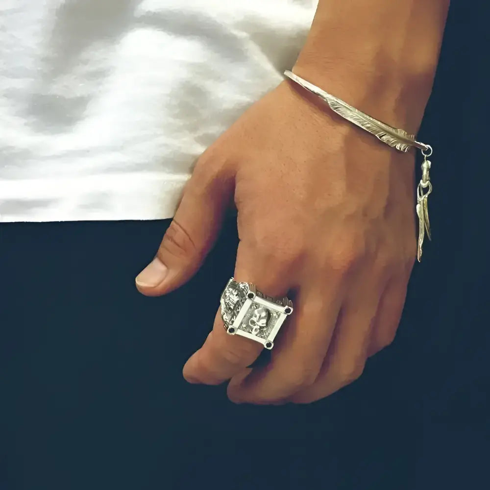 Silver skull ring and feather bracelet.