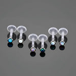 Labret piercings with opal ends.