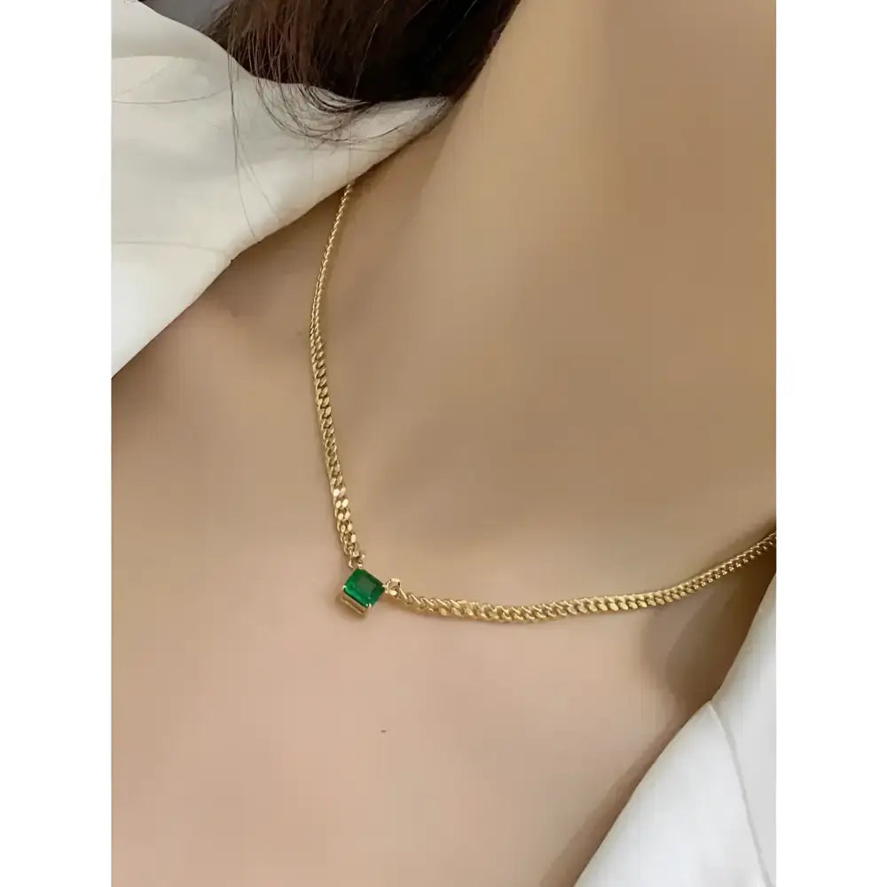Gold chain necklace with green square pendant.