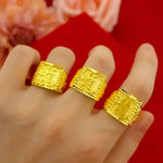 Three gold rings with square faces.