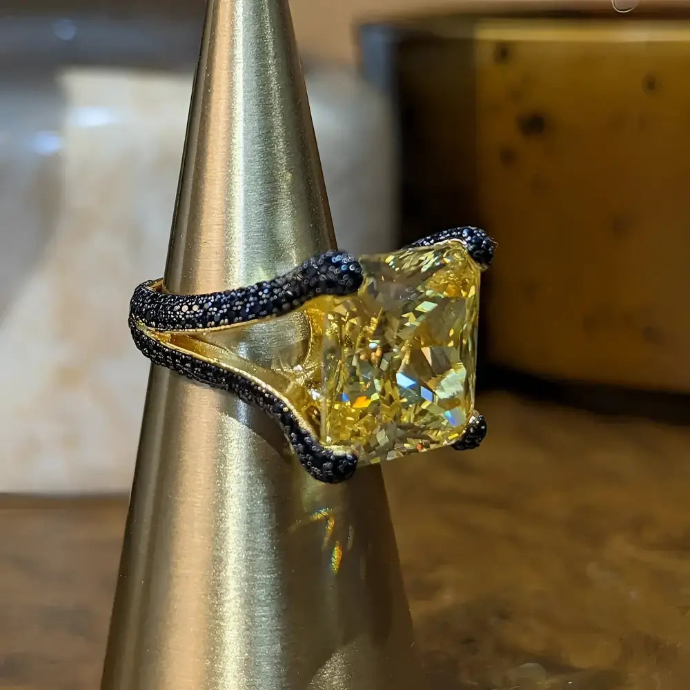 Yellow gemstone ring with black accents.