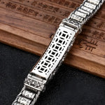 Silver bracelet with geometric cutouts.