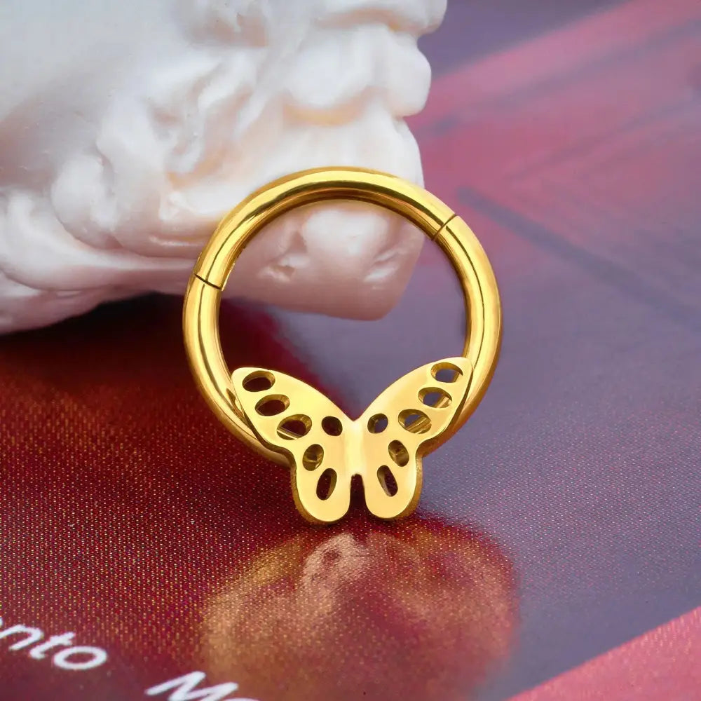 Gold-colored butterfly septum ring.