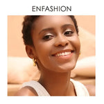 Smiling woman wearing gold earrings.