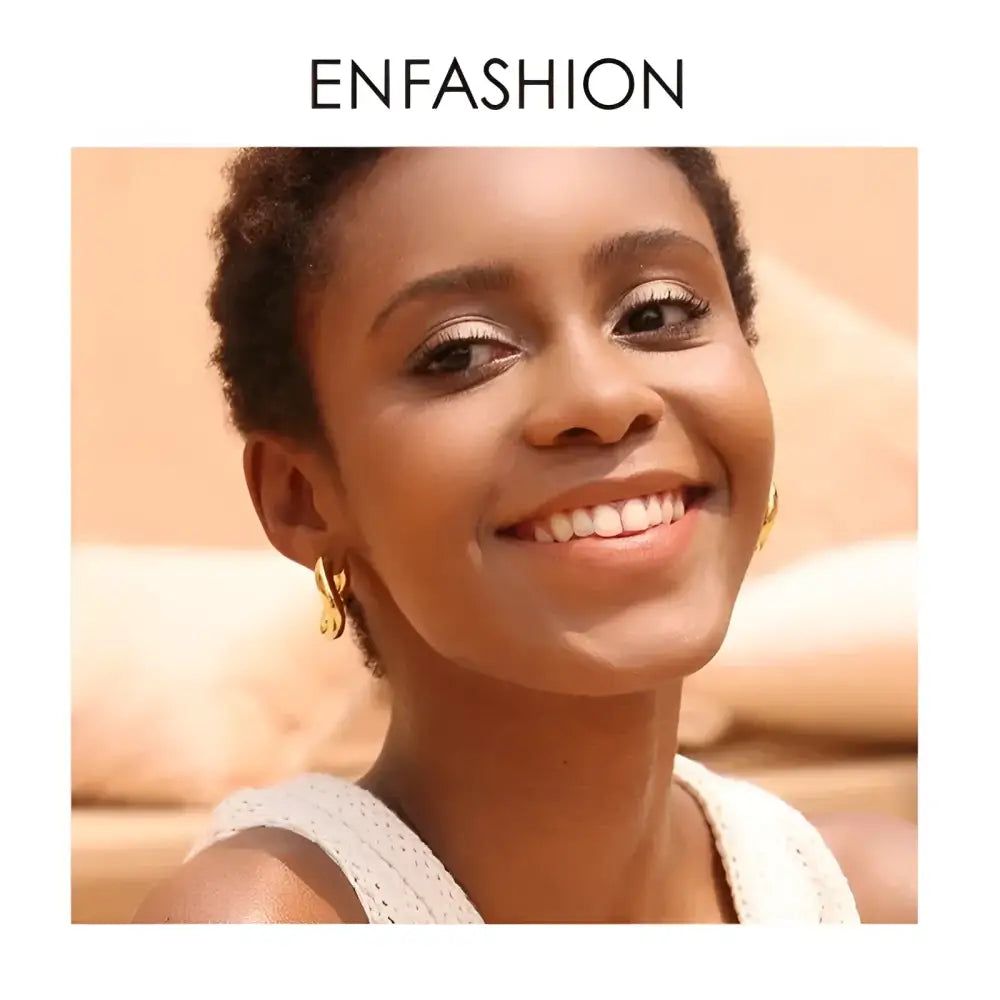 Smiling woman wearing gold earrings.