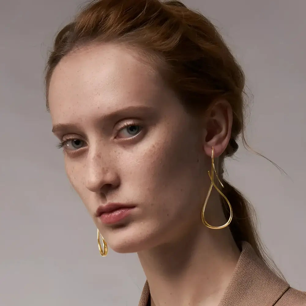 Gold teardrop earrings.