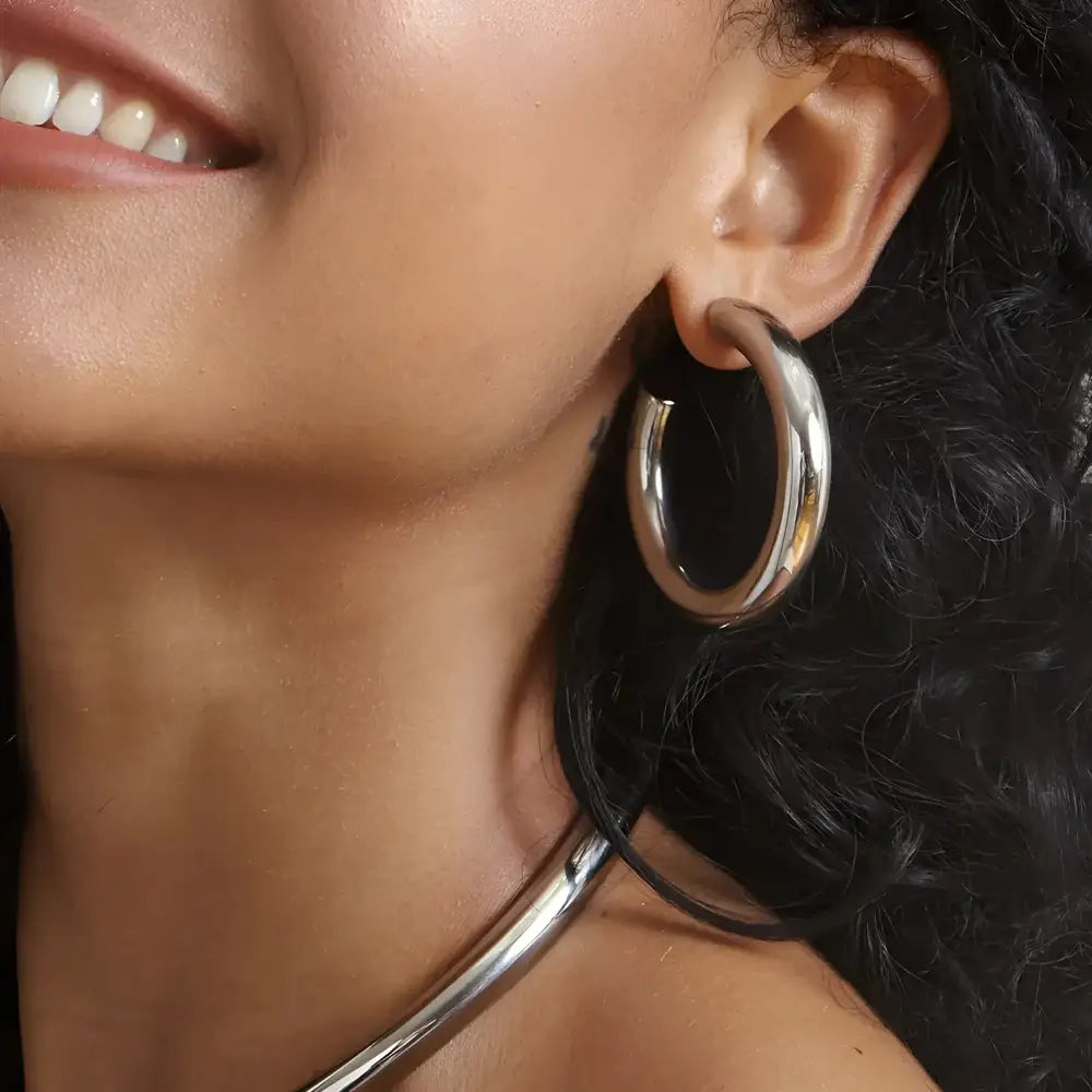 Shiny silver hoop earring.