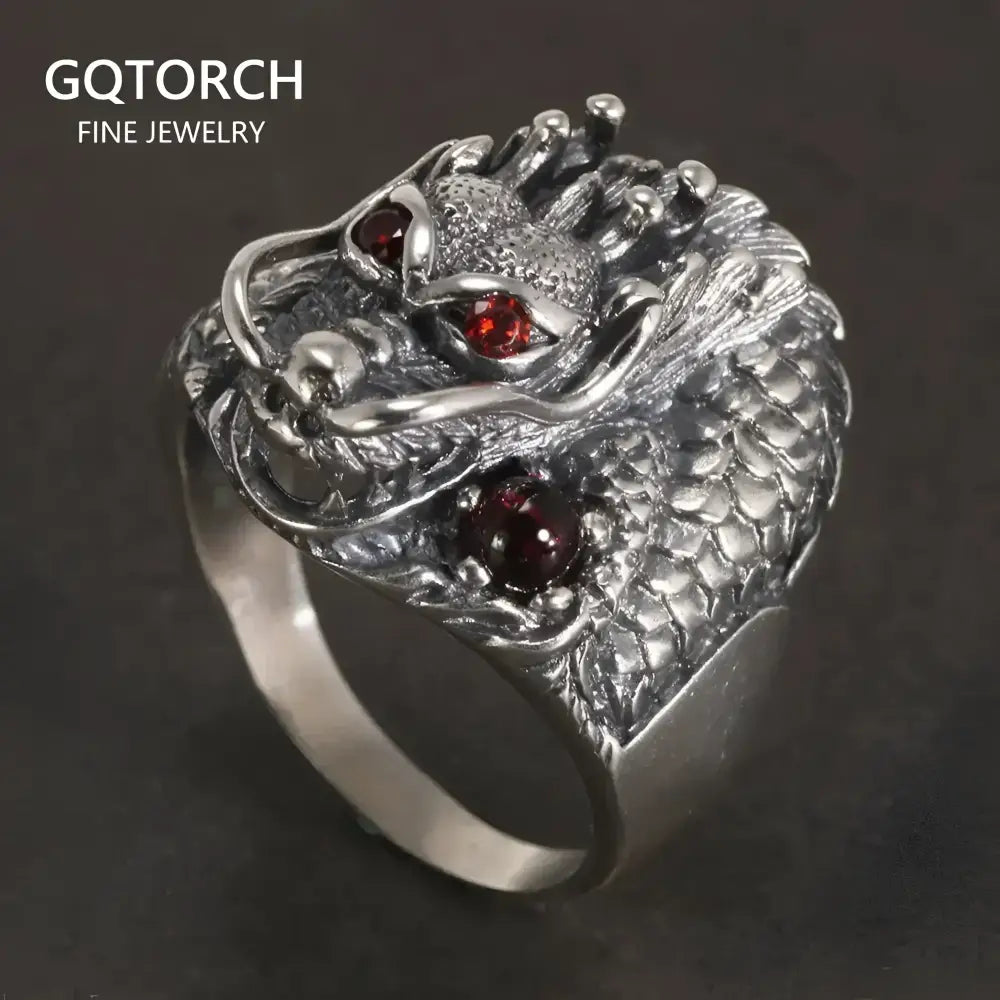 Silver dragon ring with red gemstones.