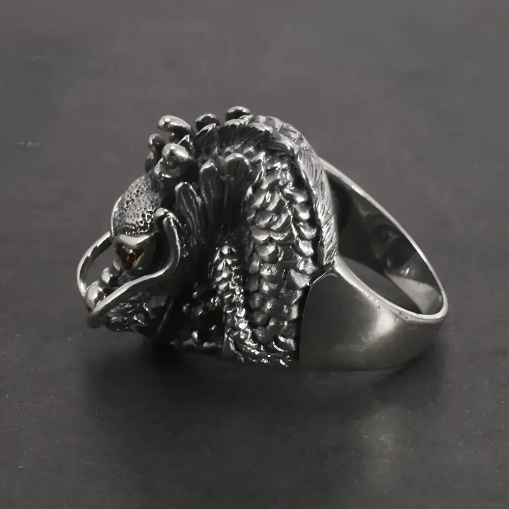 Silver dragon ring with red eyes.