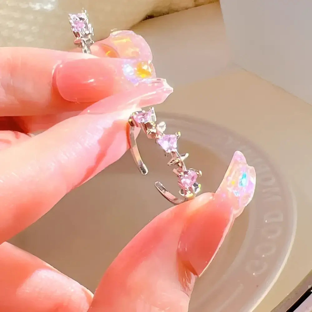 Silver ear cuff with pink heart-shaped stones.