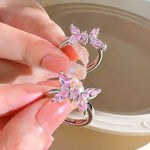 Two silver rings with pink butterfly gems.
