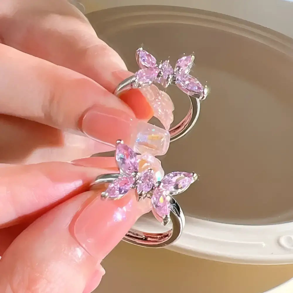 Two silver rings with pink butterfly gems.