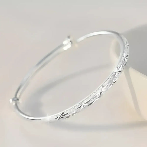 Silver starburst bangle.