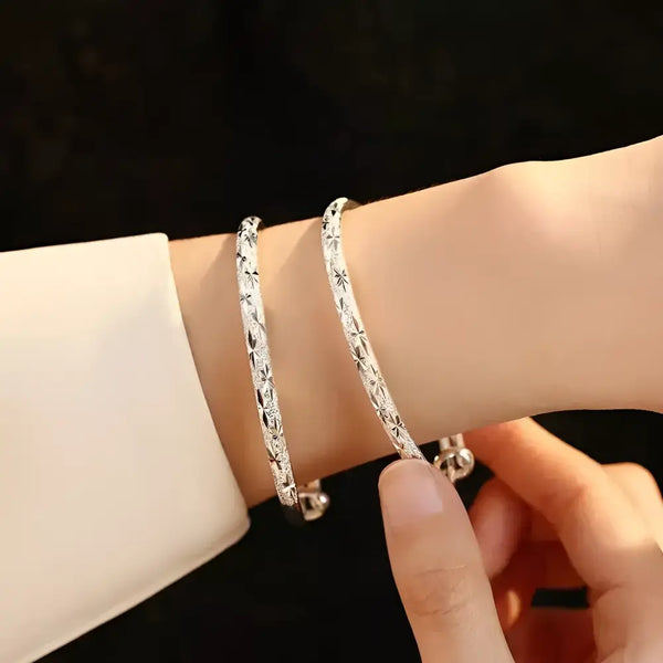 Two silver star-patterned bangles.