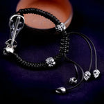 Braided black bracelet with skull beads.