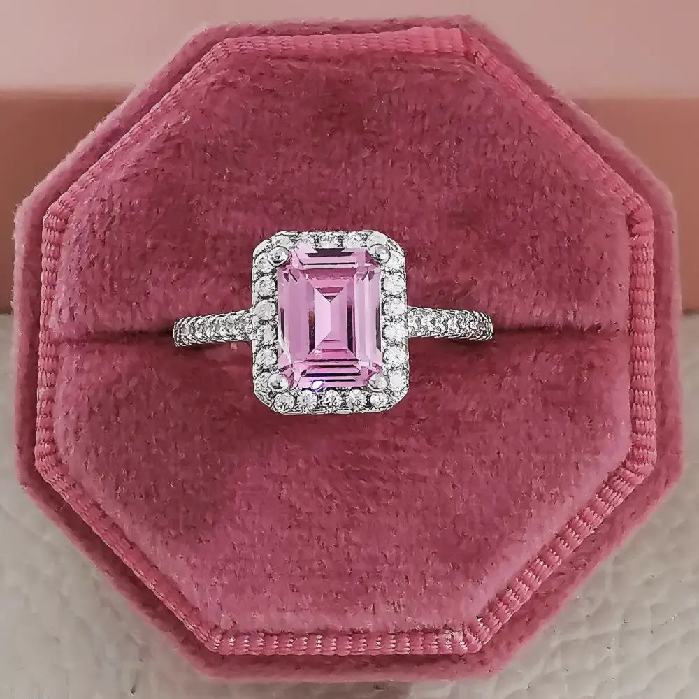 Pink emerald-cut ring with diamond halo.