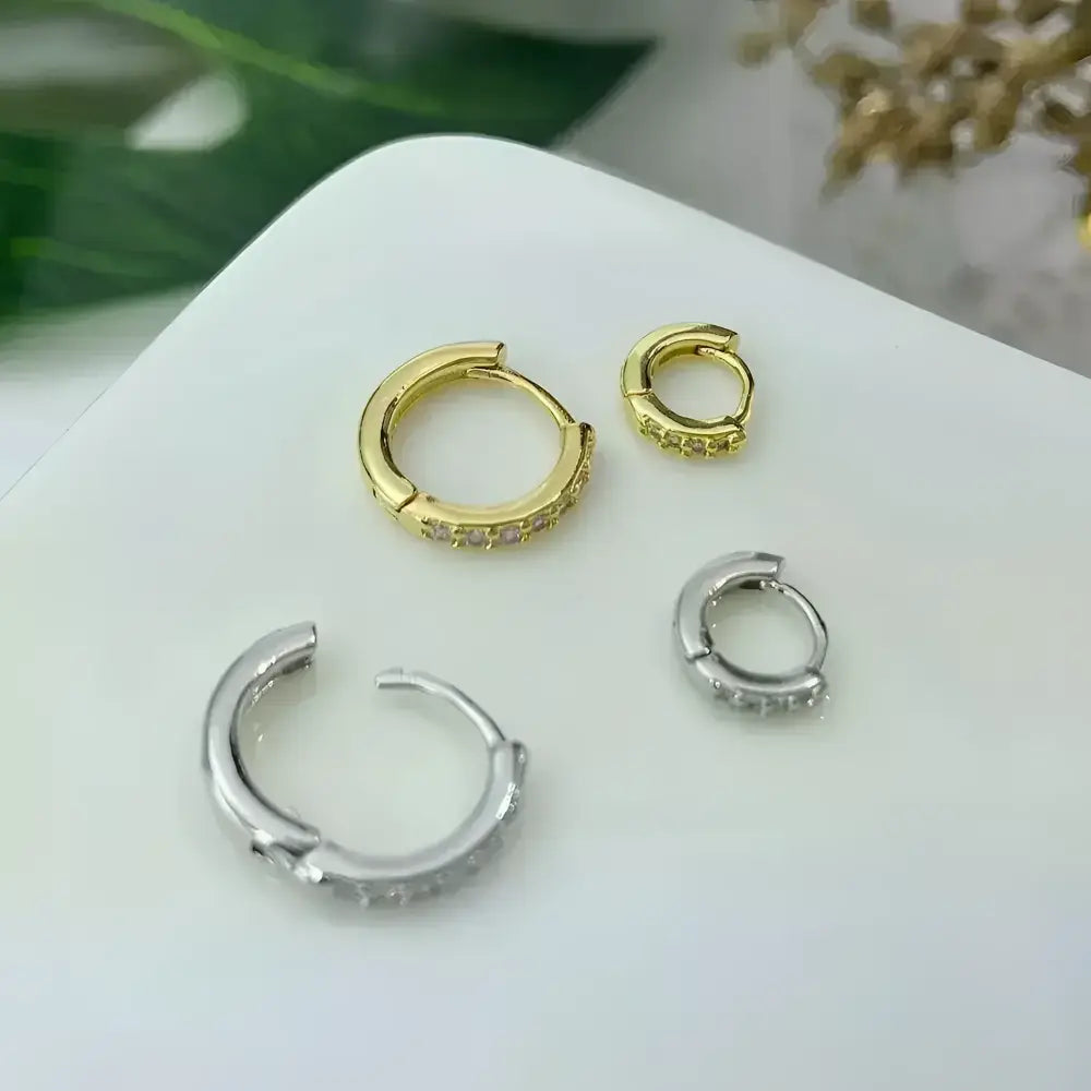 Gold and silver hoop earrings with embedded crystals.