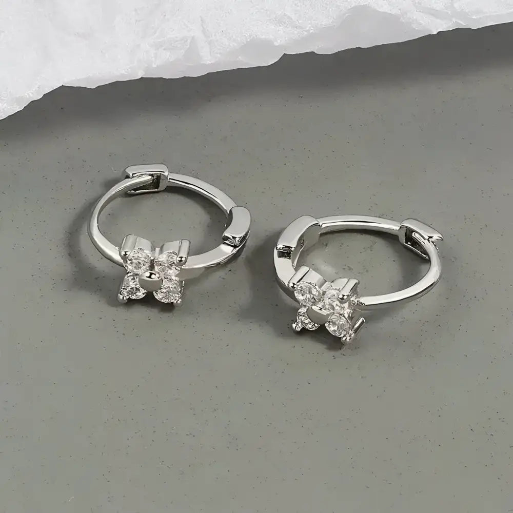 Silver hoop earrings with floral accents.