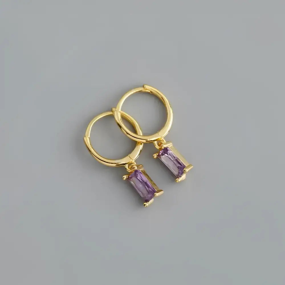 Gold hoop earrings with purple rectangular gems.