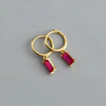 Gold hoop earrings with ruby pendants.