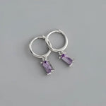 Silver hoop earrings with purple rectangular gems.