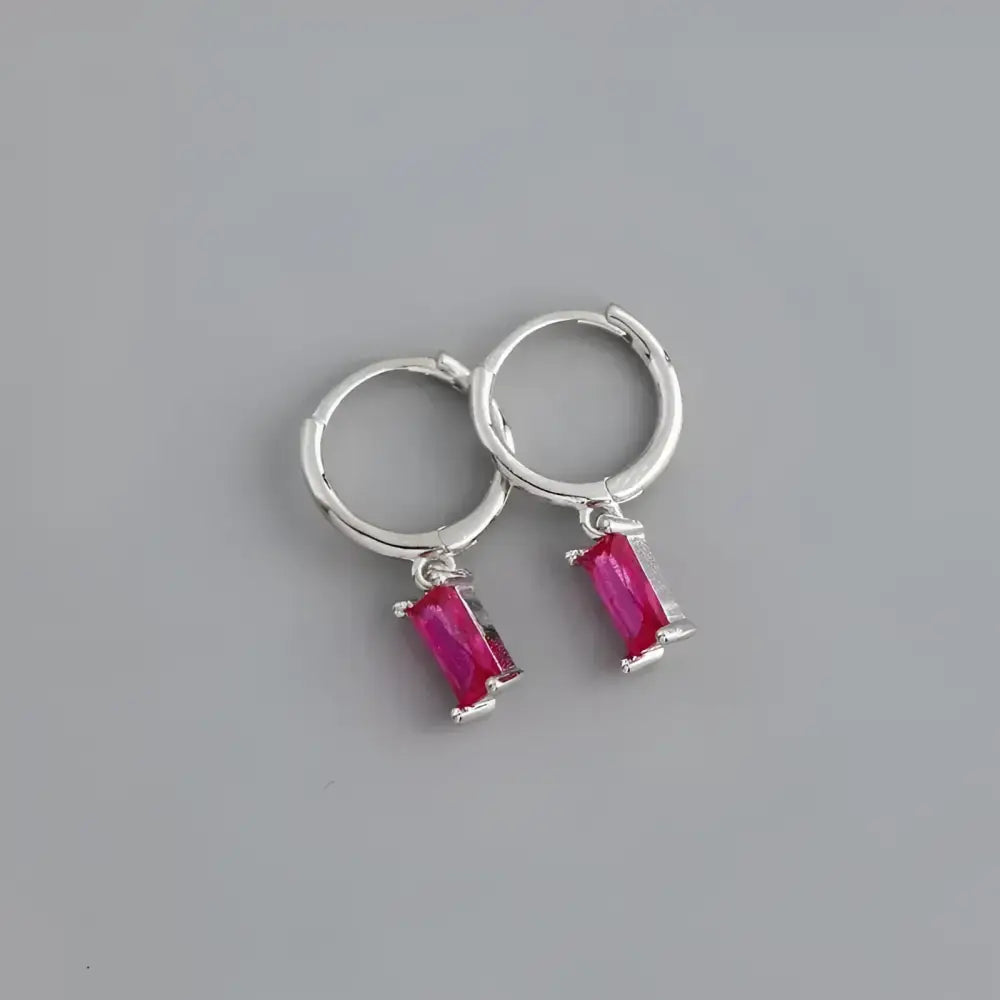 Silver hoop earrings with pink rectangular gems.