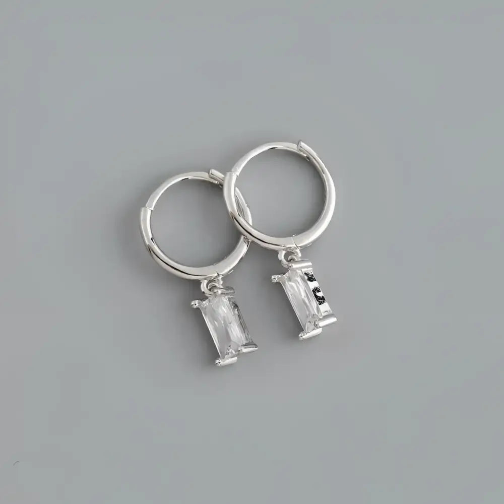 Silver hoop earrings with rectangular crystal pendants.