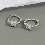 Silver hoop earrings with floral crystal accents.