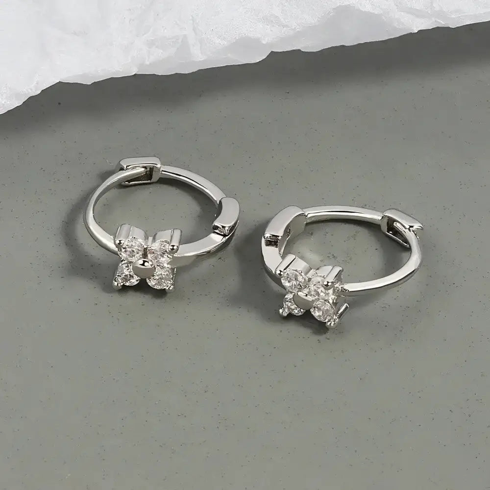 Silver hoop earrings with floral crystal accents.