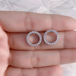 Two circular diamond earrings.