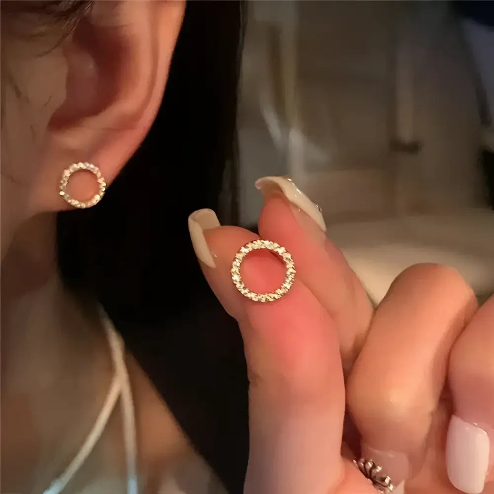 Circular gold stud earrings.