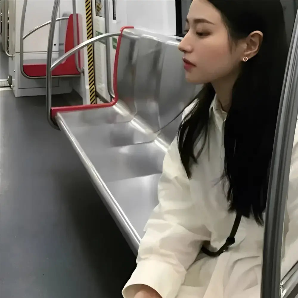 Woman sitting on subway seat.