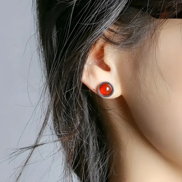 Round red stud earring.