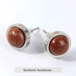 Pair of round, brown, glittery stud earrings.