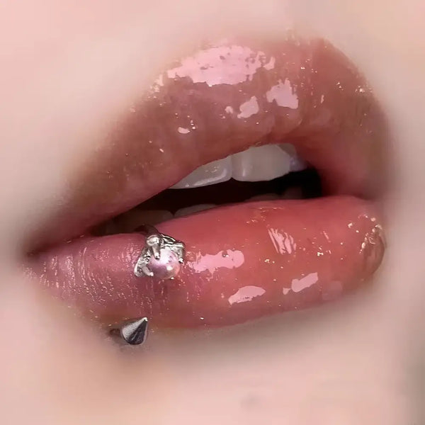 Glossy lips with piercings.