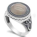 Silver ring with a round, gray stone.
