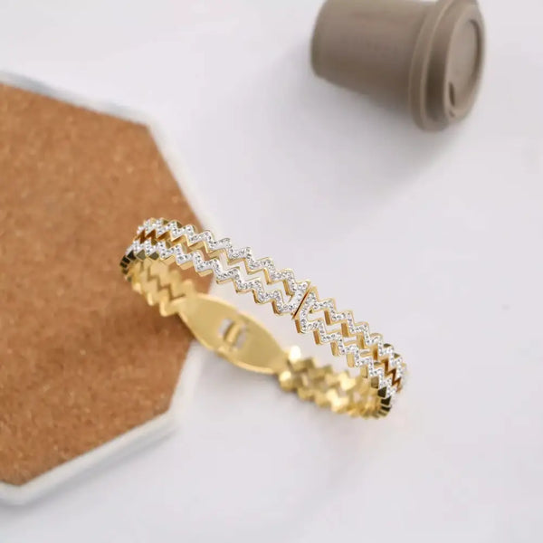 Gold zigzag bangle with embedded crystals.
