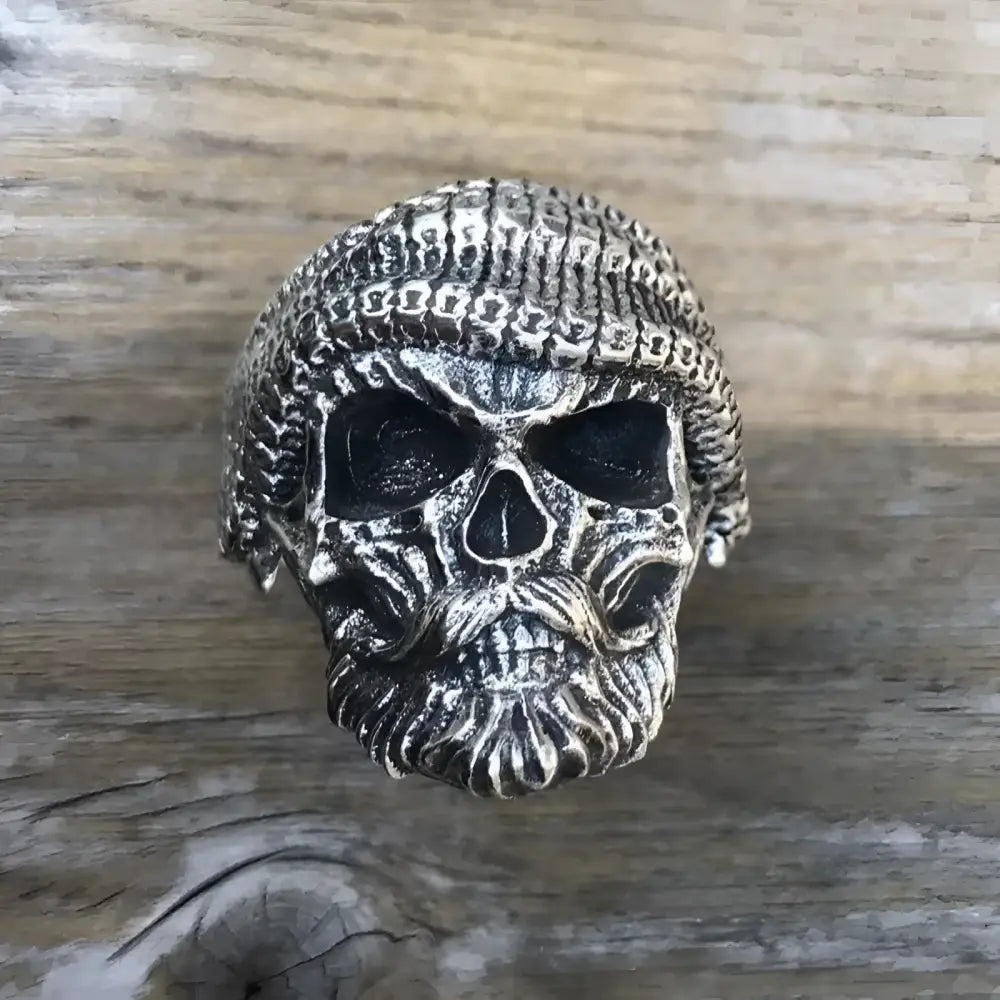 Silver skull ring with beard and cap.