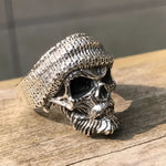 Silver skull ring with knit cap.