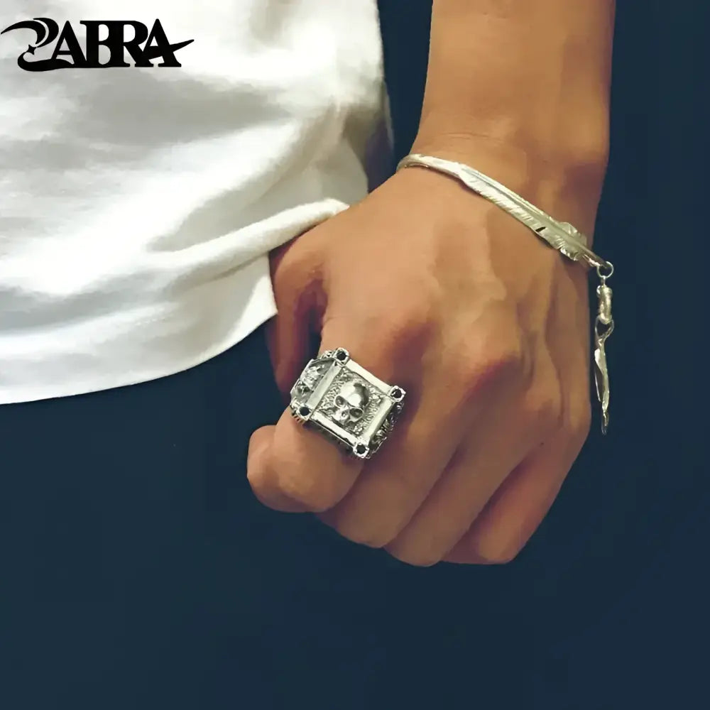 Silver skull ring and feather bracelet.