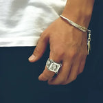 Silver skull ring and feather bracelet.