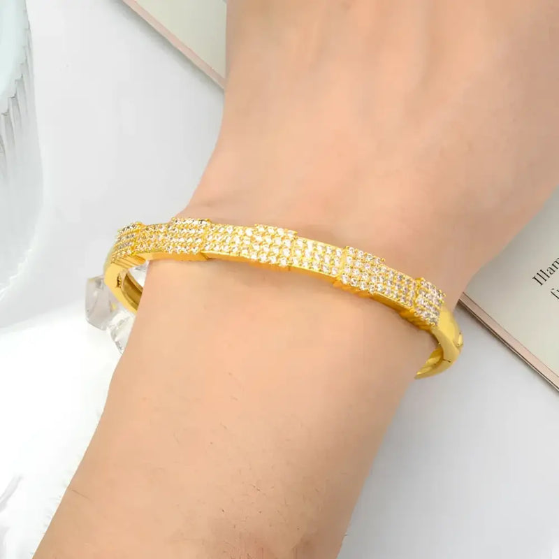 Gold-toned, diamond-studded bangle bracelet.